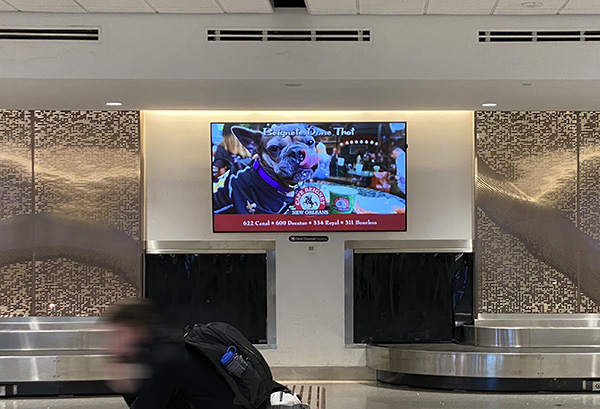 Cafe Beignet on screen in baggage claim